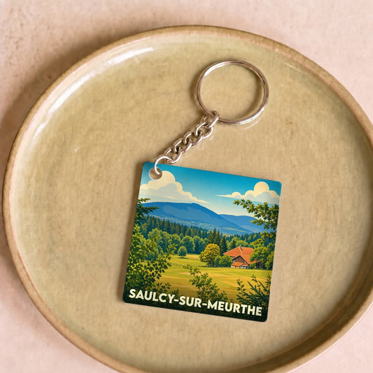 Porte-clés souvenir de la ville de Saulcy-sur-Meurthe avec une illustration paysagère stylisée.