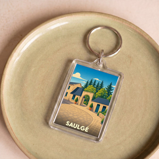 Porte-clés souvenir de la ville de Saulgé avec une illustration stylisée.