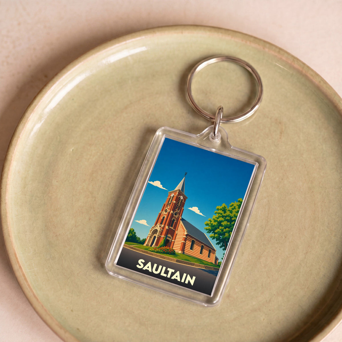 Porte-clés souvenir de la ville de Saultain avec une illustration stylisée de son église.