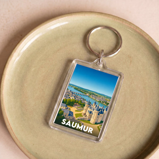 Porte-clés souvenir de la ville de Saumur avec une illustration colorée du château et de la Loire.