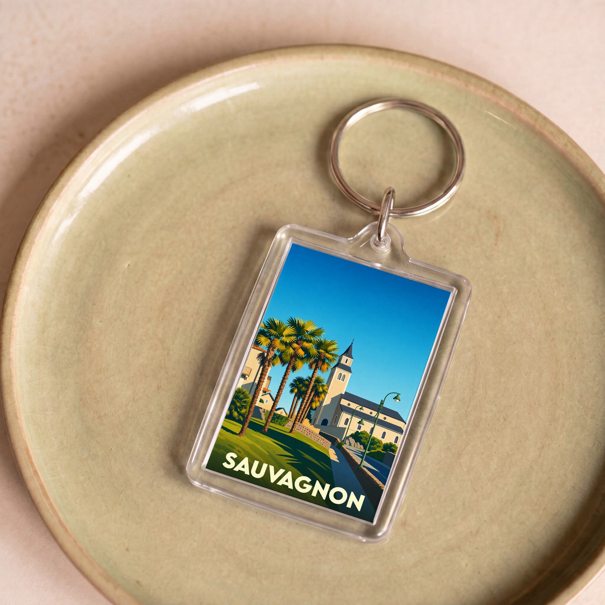 Porte-clés souvenir de la ville de Sauvagnon avec une illustration stylisée.