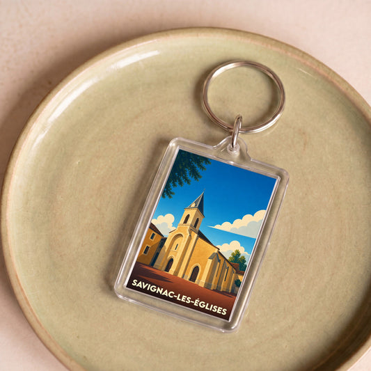 Porte-clés souvenir de la ville de Savignac-les-Églises avec une illustration stylisée de son église.