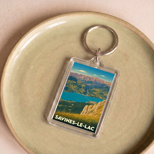 Porte-clés souvenir de la ville de Savines-le-Lac avec une illustration stylisée du lac et des montagnes.