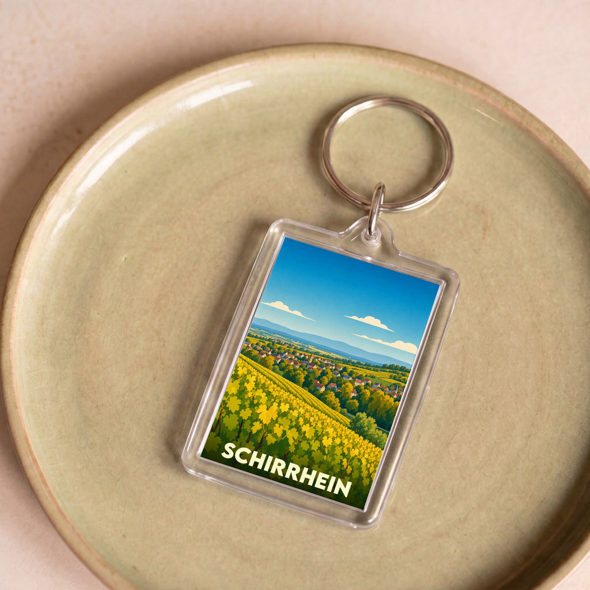 Porte-clés souvenir de la ville de Schirrhein avec une illustration stylisée de son paysage.