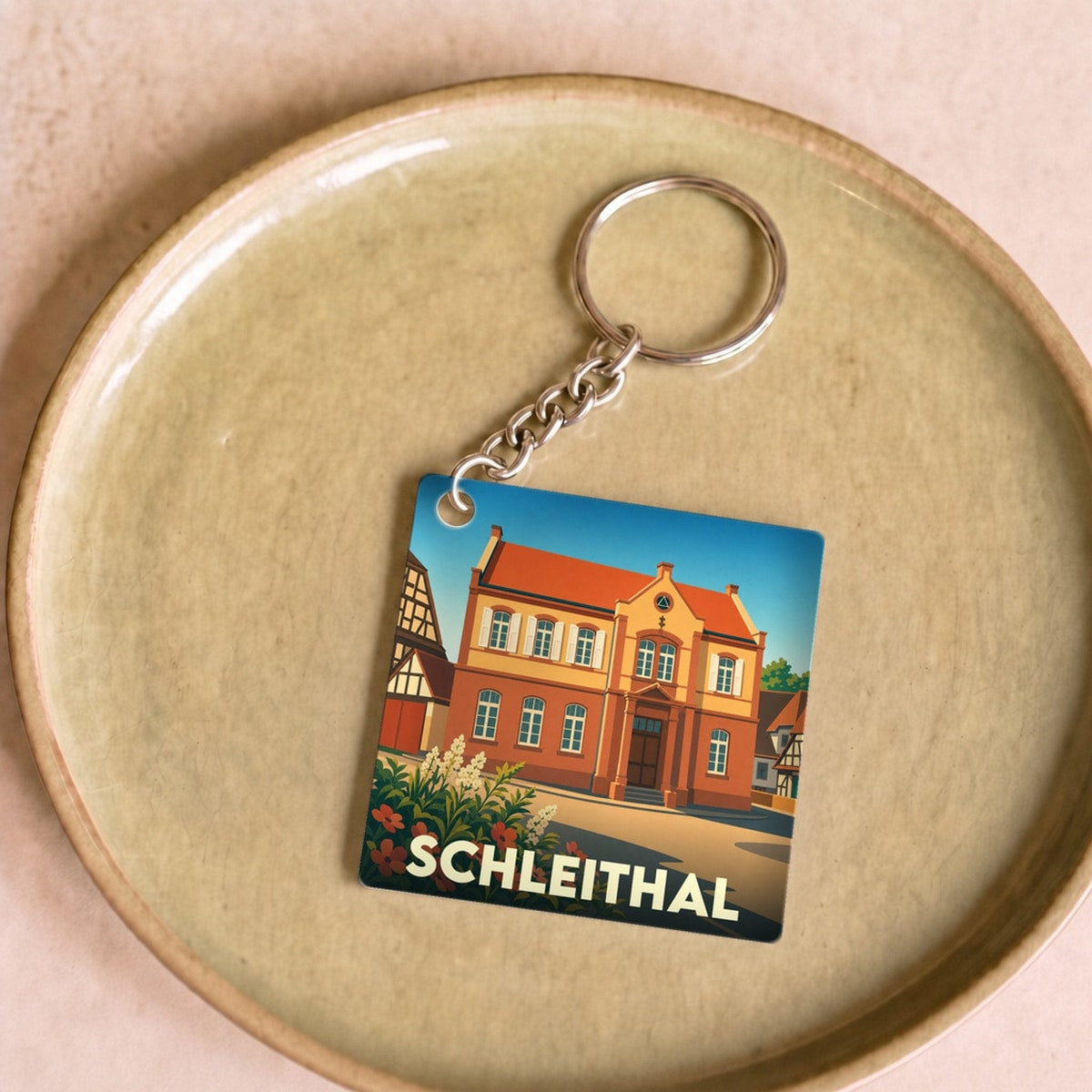 Porte-clés souvenir de la ville de Schleithal avec une illustration stylisée de son architecture.