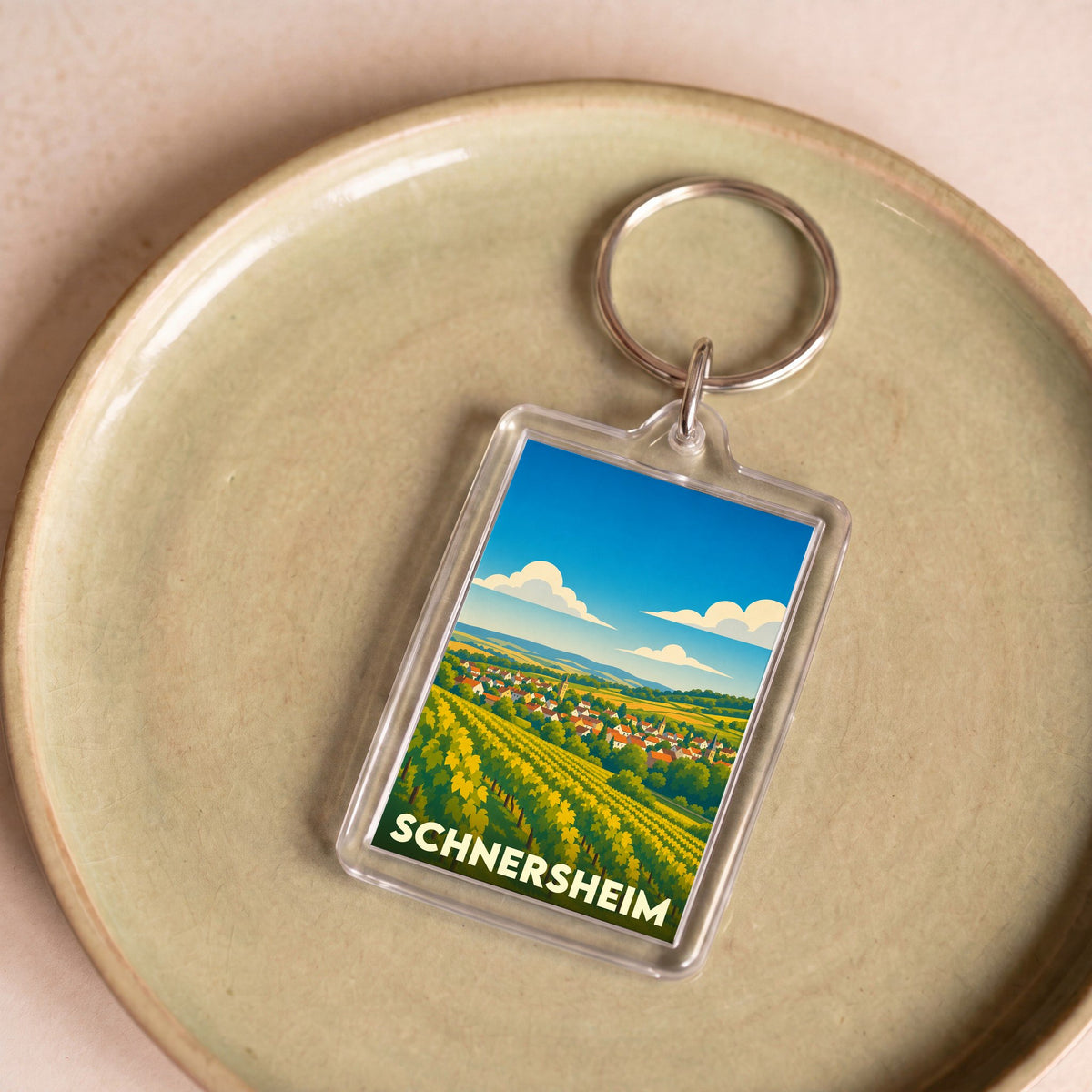 Porte-clés souvenir de la ville de Schnersheim avec une illustration stylisée de vignobles et de maisons.