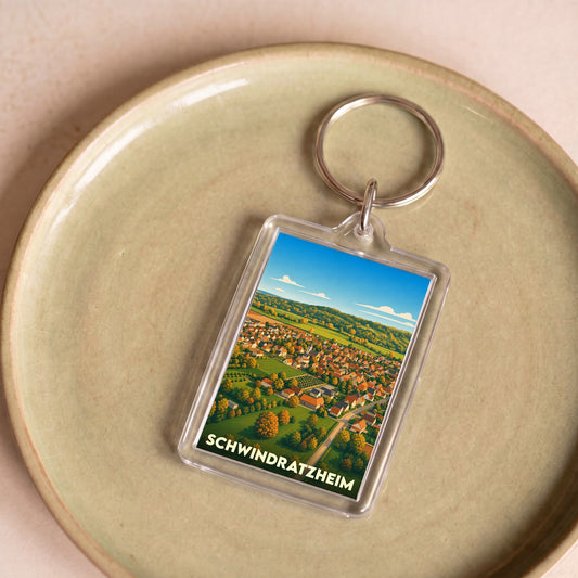 Porte-clés souvenir de la ville de Schwindratzheim avec une illustration paysagère stylisée.
