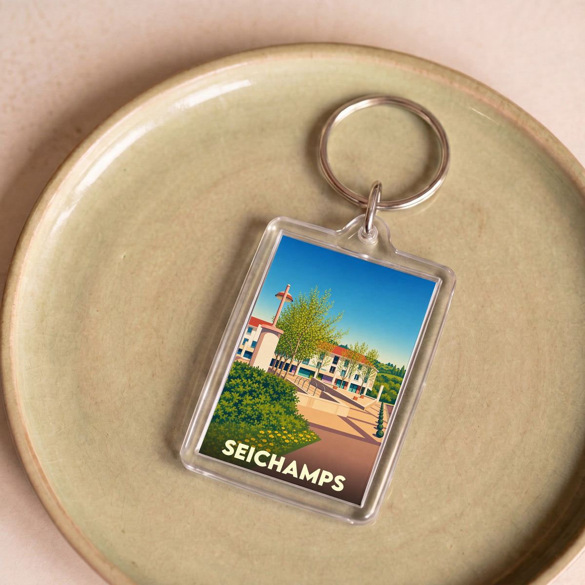 Porte-clés souvenir de la ville de Seichamps avec une illustration stylisée.