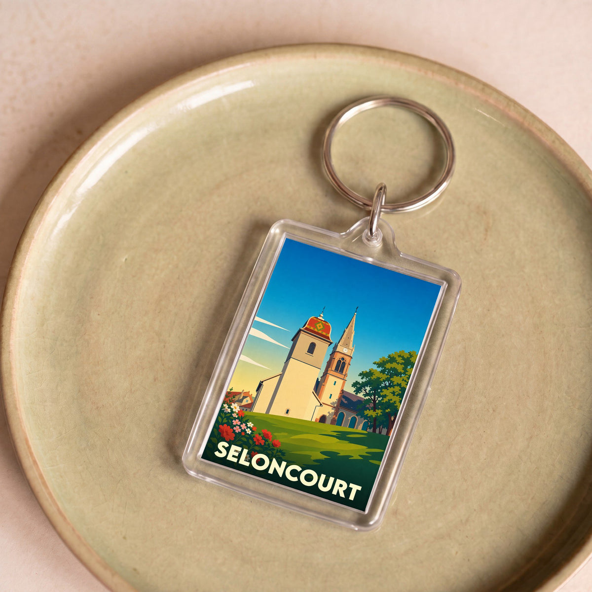 Porte-clés souvenir de la ville de Seloncourt avec une illustration stylisée.