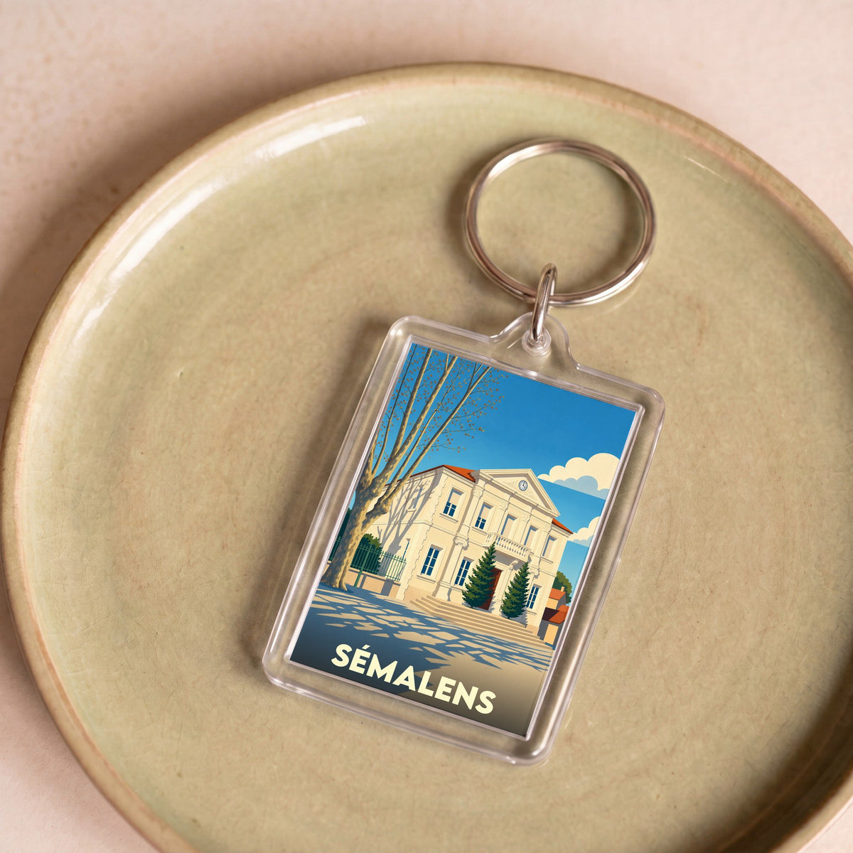 Porte-clés souvenir de la ville de Sémalens avec une illustration stylisée de sa mairie.