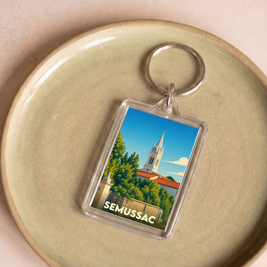 Porte-clés souvenir de la ville de Semussac avec une illustration stylisée de son église.