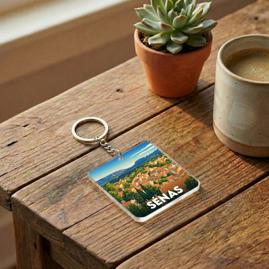 Porte-clés souvenir de la ville de Sénas avec une illustration stylisée de ses paysages provençaux.