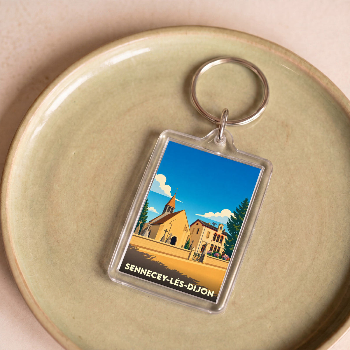 Porte-clés souvenir de la ville de Sennecey-lès-Dijon avec une illustration stylisée.