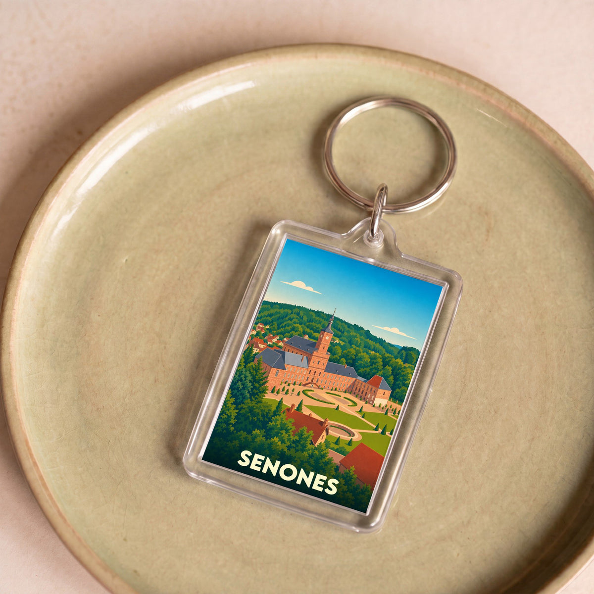 Porte-clés souvenir de la ville de Senones avec une illustration stylisée de son abbaye.