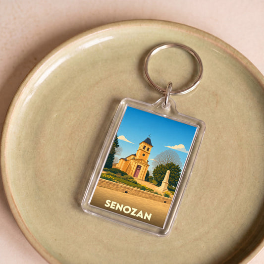 Porte-clés souvenir de la ville de Senozan avec une illustration stylisée de son église.