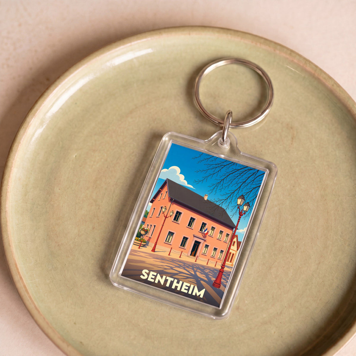 Porte-clés souvenir de la ville de Sentheim avec une illustration stylisée.