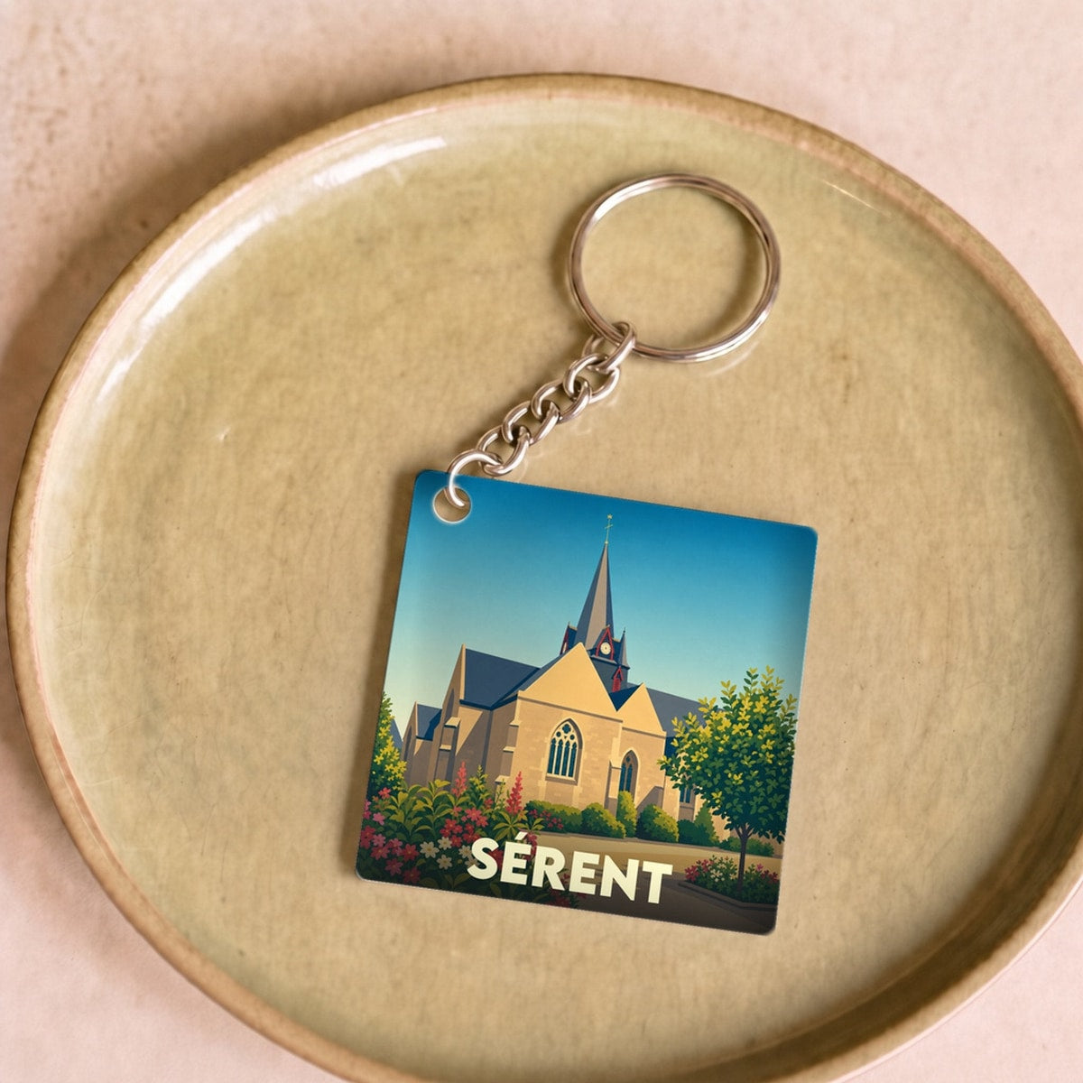 Porte-clés souvenir de la ville de Sérent avec une illustration stylisée de son église.