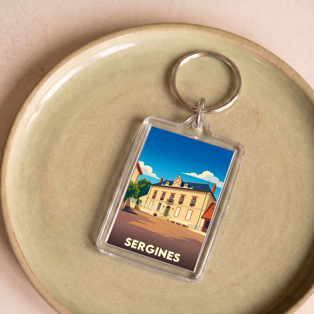 Porte-clés souvenir de la ville de Sergines avec une illustration stylisée de la mairie.