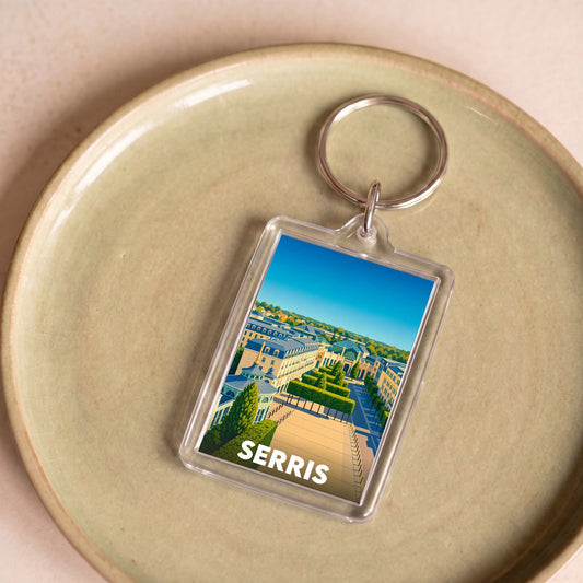 Porte-clés souvenir de la ville de Serris avec une illustration paysagère colorée.