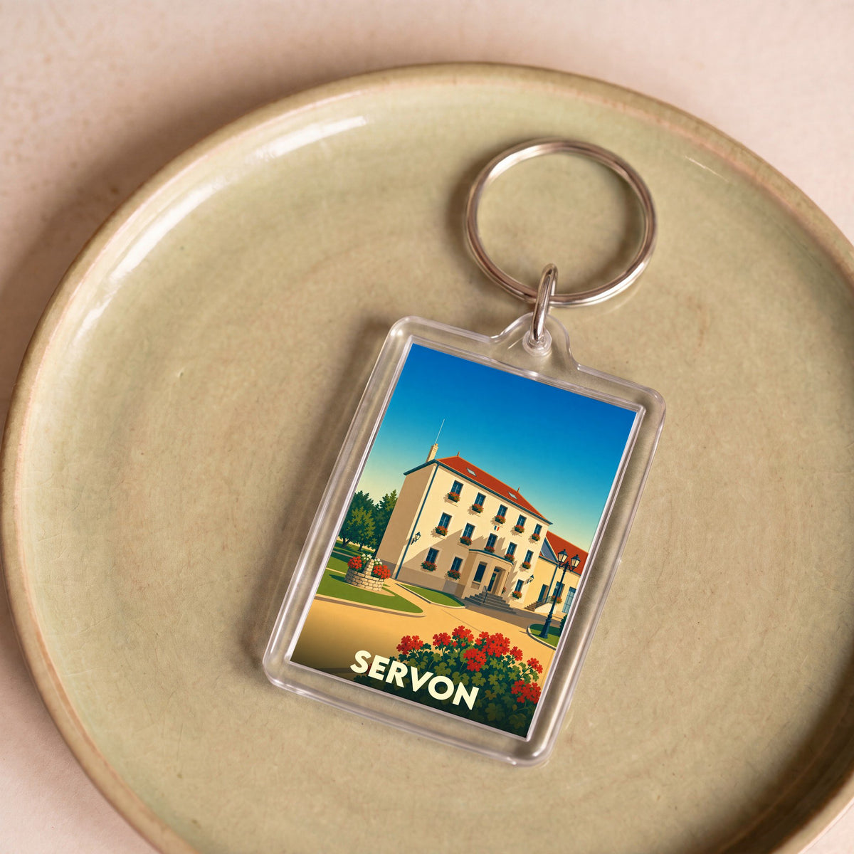 Porte-clés souvenir de la ville de Servon avec une illustration stylisée d'un bâtiment remarquable.