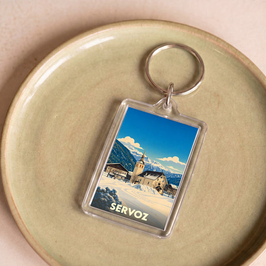 Porte-clés souvenir de la ville de Servoz avec une illustration hivernale stylisée.