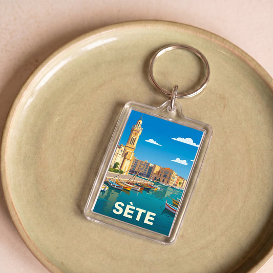 Porte-clés souvenir de la ville de Sète avec une illustration stylisée du port.