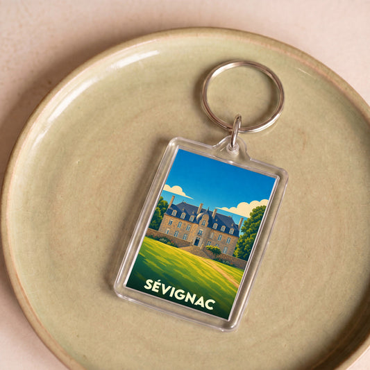 Porte-clés souvenir de la ville de Sévignac avec une illustration stylisée.