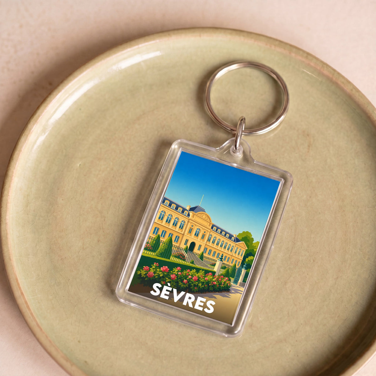 Porte-clés souvenir de la ville de Sèvres avec une illustration stylisée.