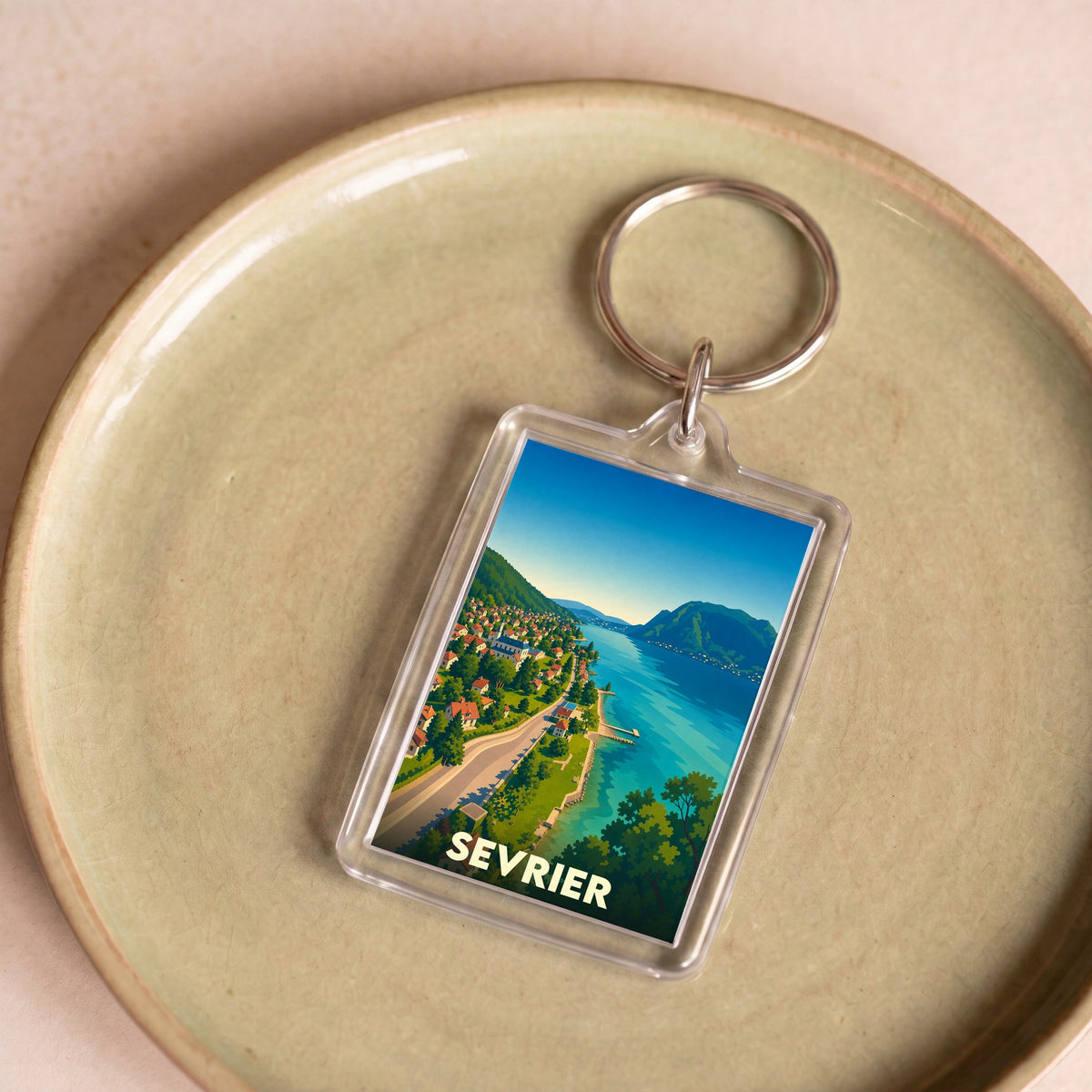 Porte-clés souvenir de la ville de Sevrier avec une illustration stylisée des bords du lac d'Annecy.