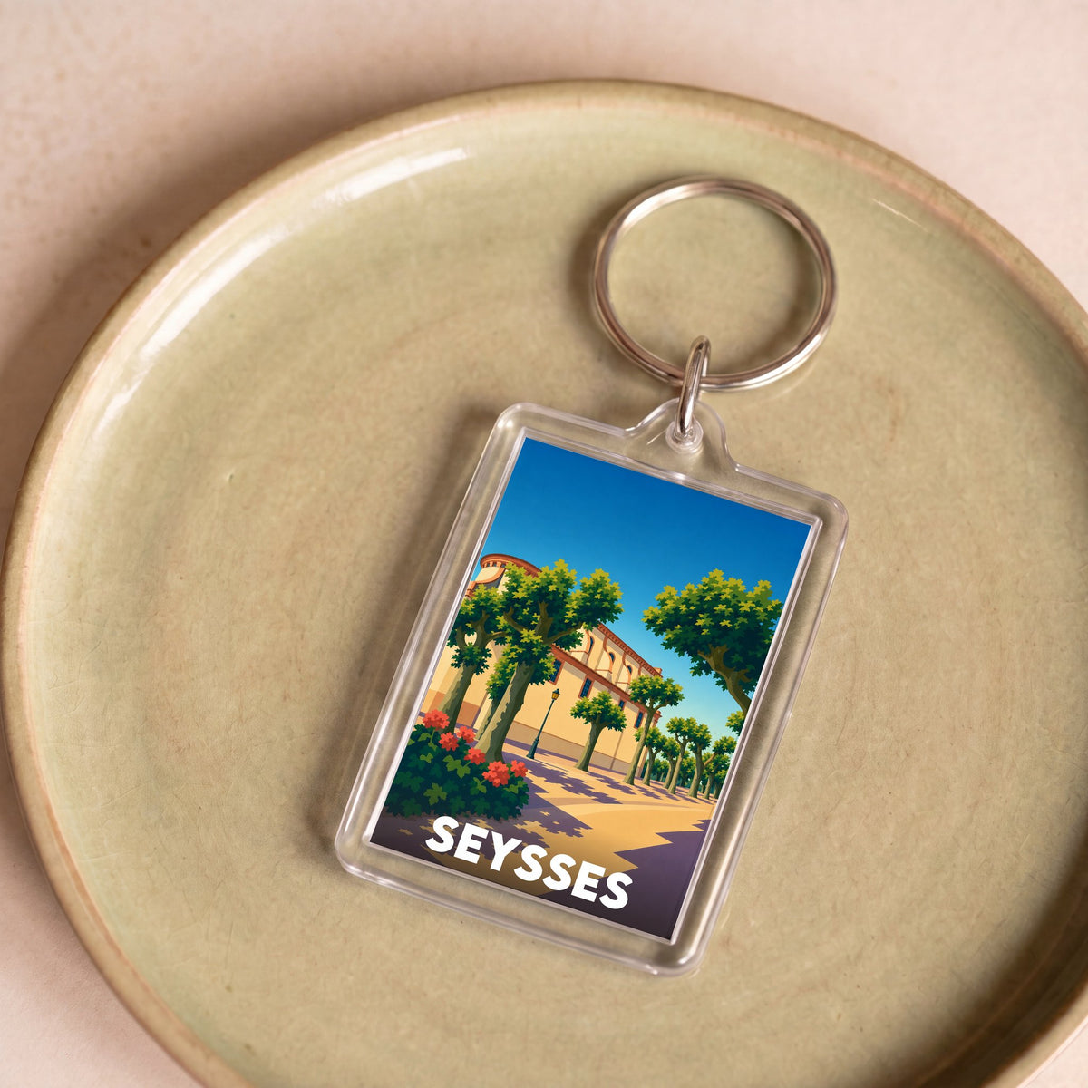 Porte-clés souvenir de la ville de Seysses avec une illustration stylisée.