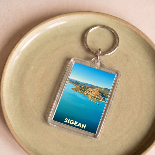 Porte-clés souvenir de la ville de Sigean avec une illustration panoramique du littoral.