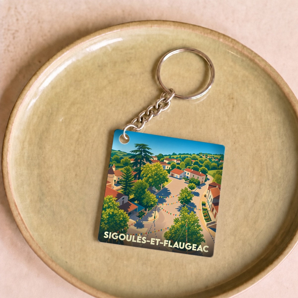 Porte-clés souvenir de la ville de Sigoulès-et-Flaugeac avec une illustration stylisée.