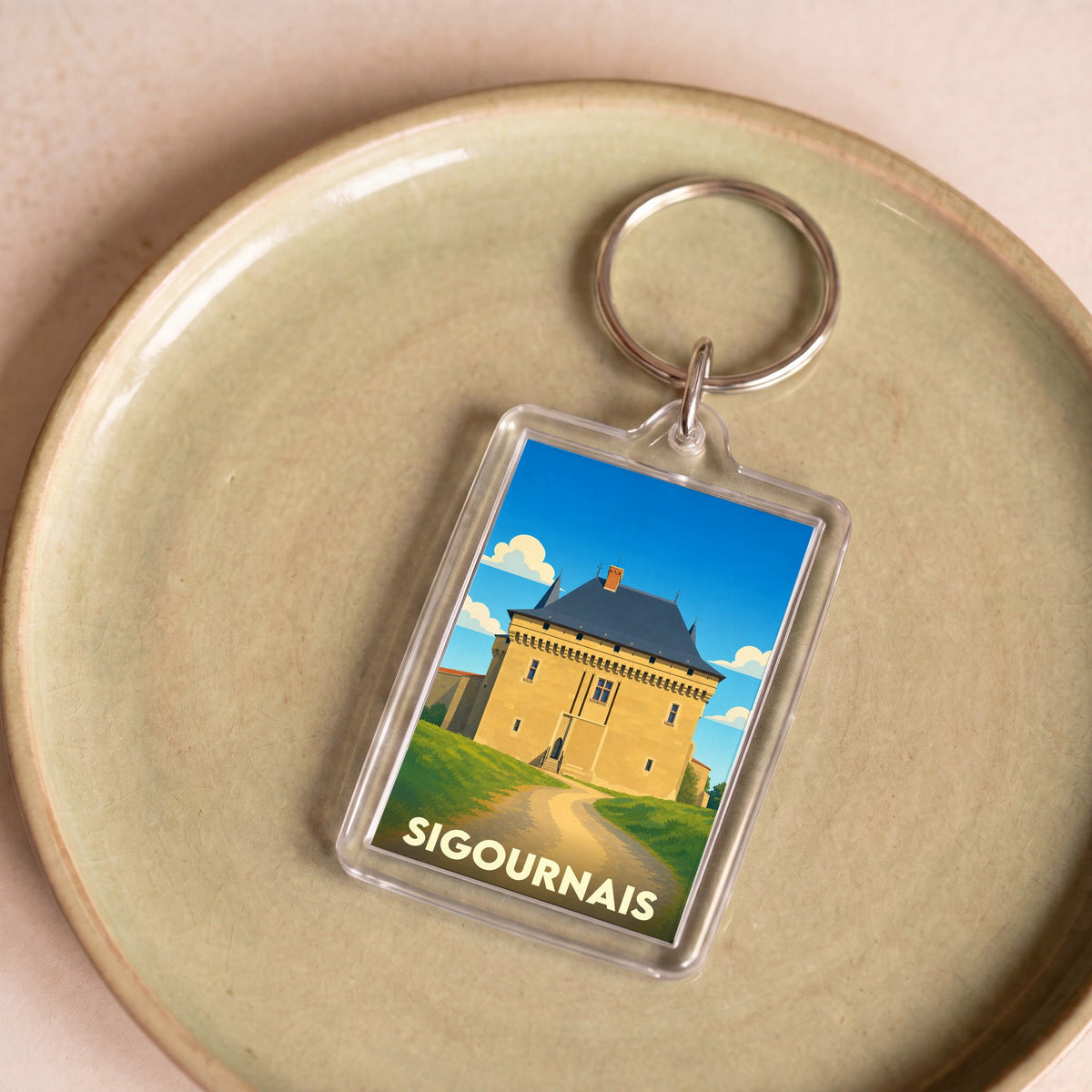 Porte-clés souvenir de la ville de Sigournais avec une illustration stylisée de son château.