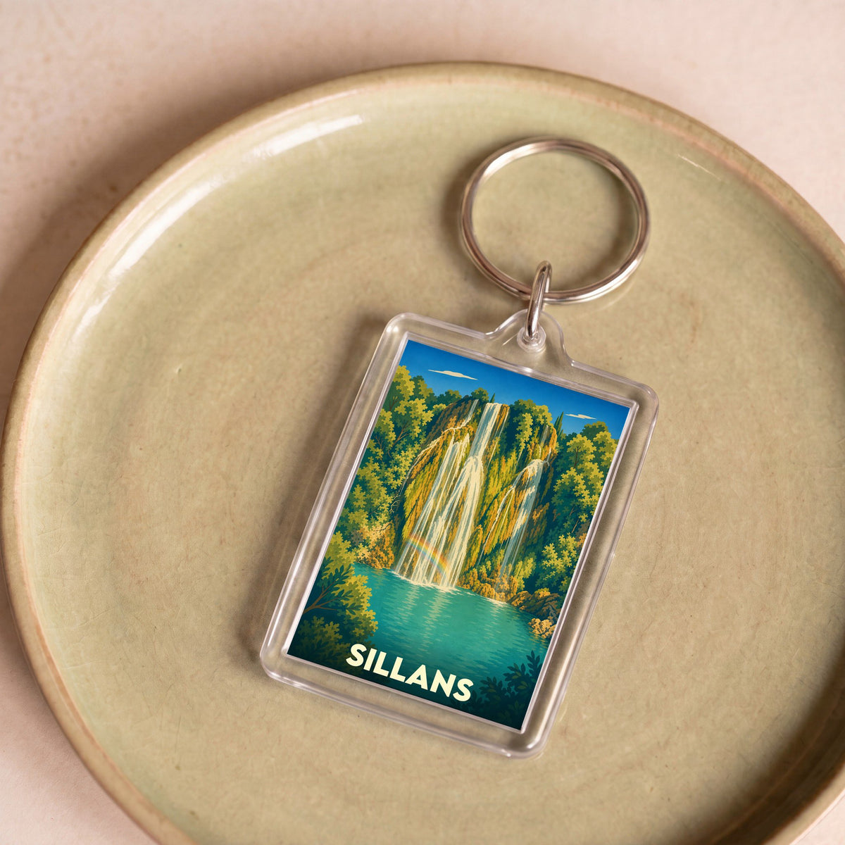 Porte-clés souvenir de la ville de Sillans avec une illustration stylisée de sa cascade.