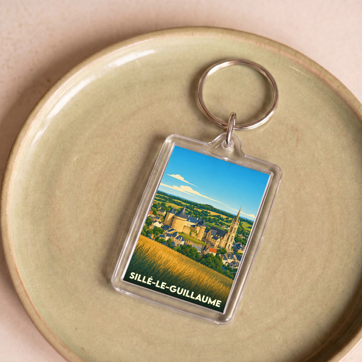 Porte-clés souvenir de la ville de Sillé-le-Guillaume avec une illustration stylisée de son château et de son église.