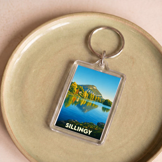 Porte-clés souvenir de la ville de Sillingy avec une illustration stylisée de son lac et des montagnes.