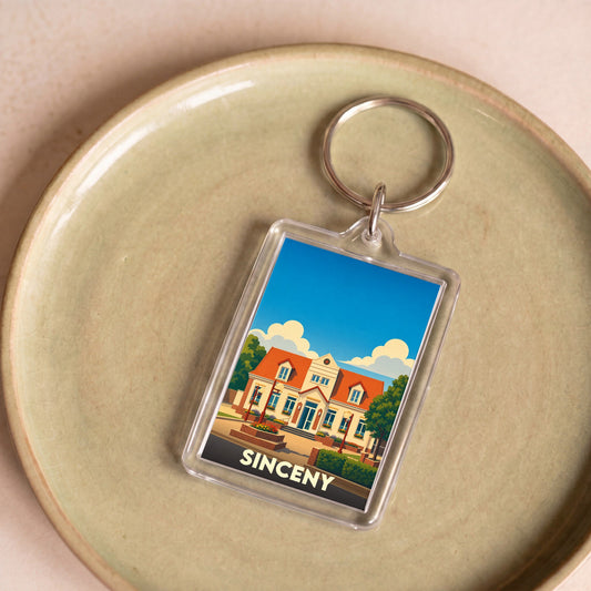 Porte-clés souvenir de la ville de Sinceny avec une illustration stylisée de sa mairie.