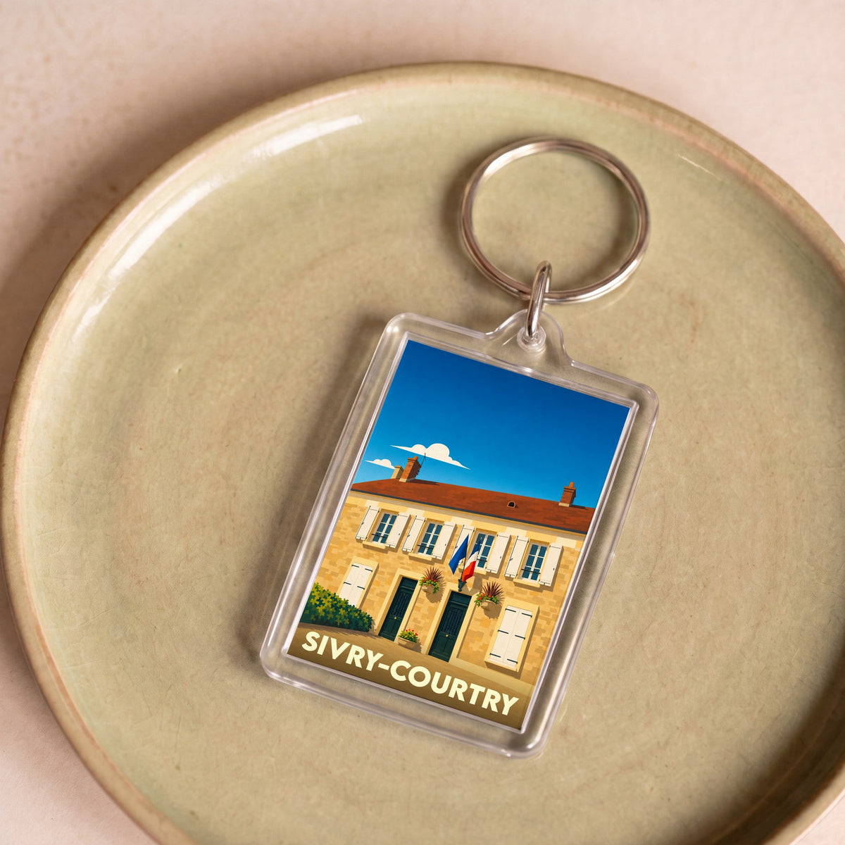 Porte-clés souvenir de la ville de Sivry-Courtry avec une illustration stylisée d'un bâtiment local.