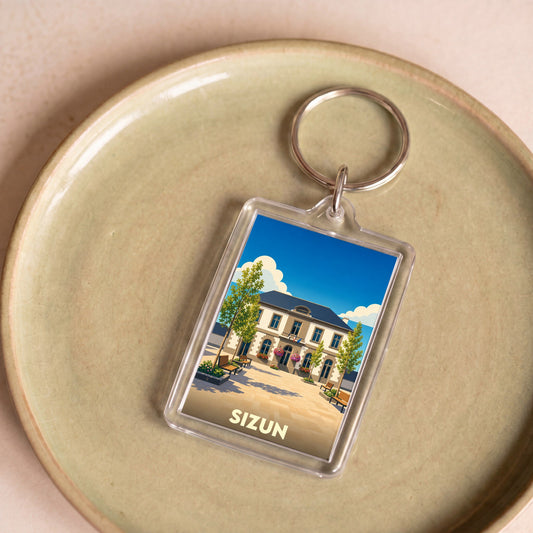 Porte-clés souvenir de la ville de Sizun avec une illustration stylisée d'un bâtiment emblématique.