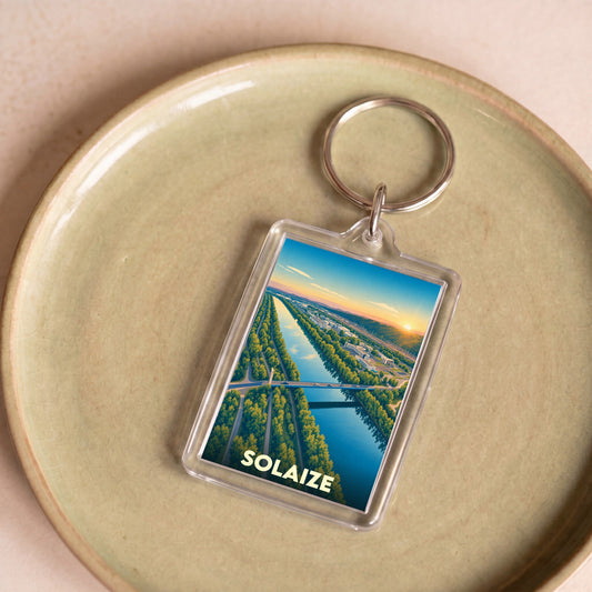 Porte-clés souvenir de la ville de Solaize avec une illustration stylisée d'un paysage fluvial au coucher du soleil.
