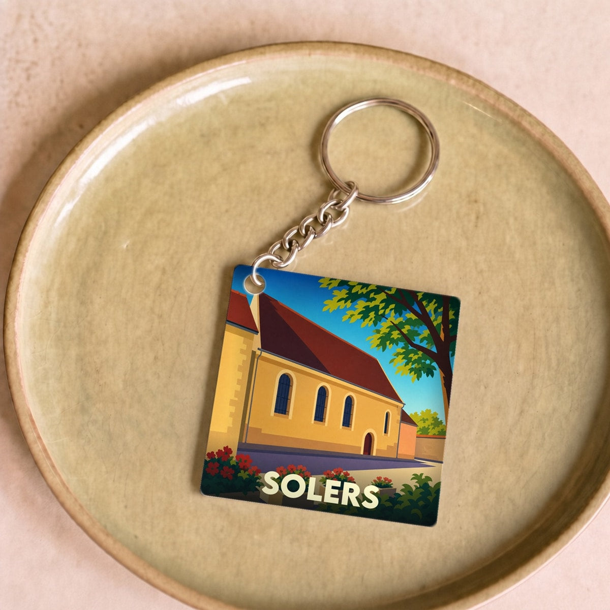 Porte-clés souvenir de la ville de Solers avec une illustration stylisée.