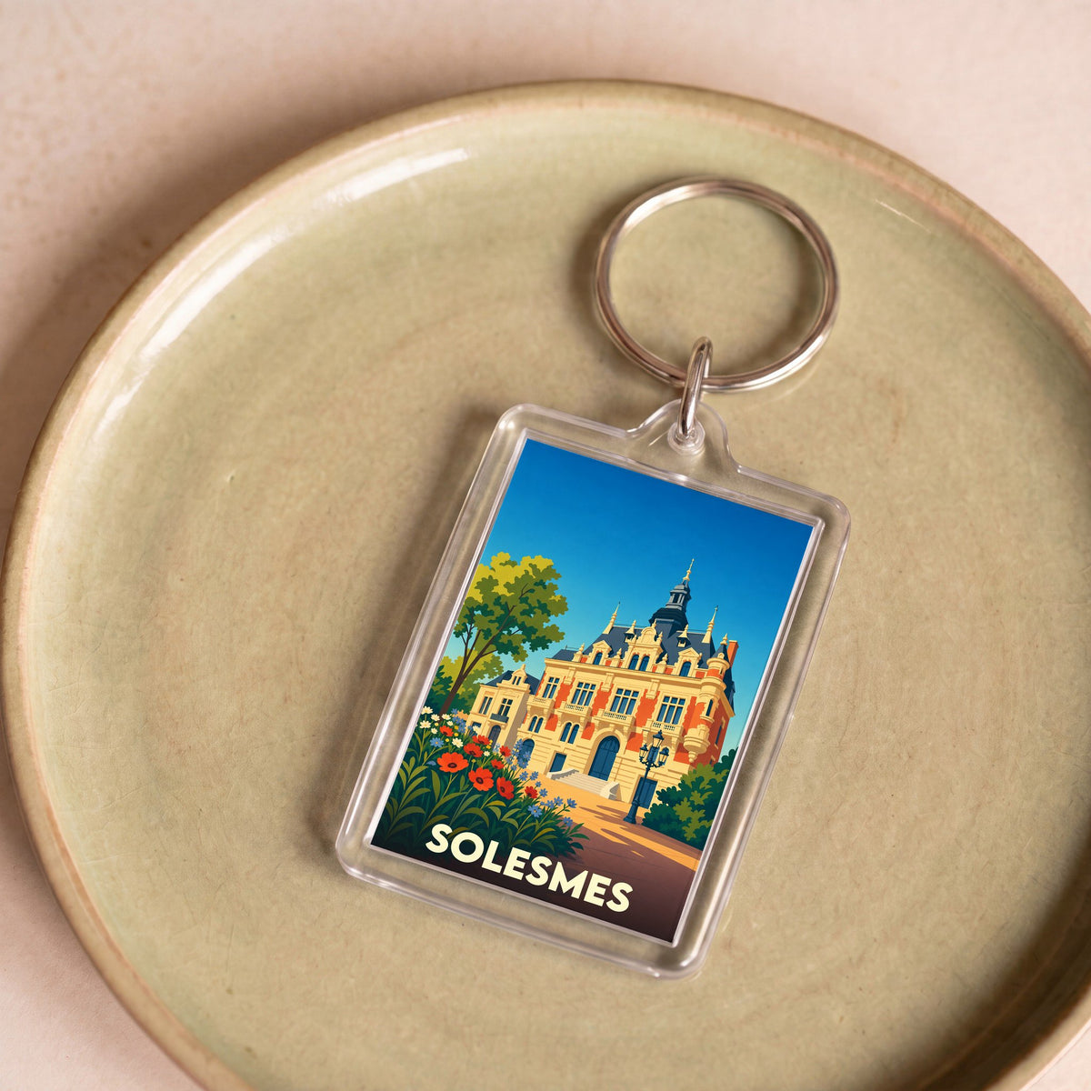 Porte-clés souvenir de la ville de Solesmes avec une illustration stylisée de son hôtel de ville.