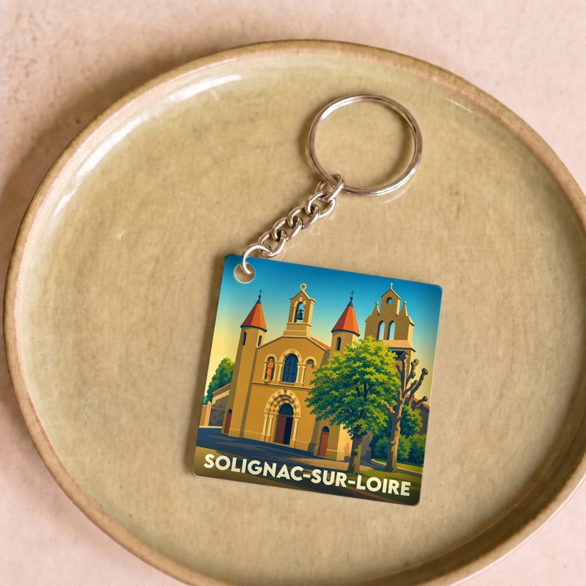 Porte-clés souvenir de Solignac-sur-Loire avec une illustration stylisée de son église.