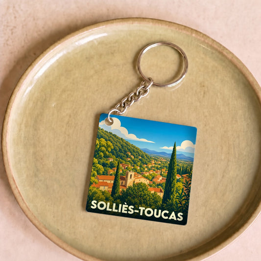 Porte-clés souvenir de la ville de Solliès-Toucas avec une illustration stylisée de son paysage vallonné.