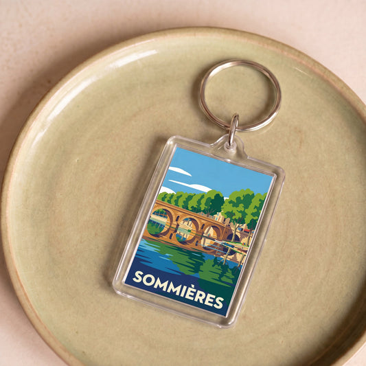 Porte-clés souvenir de la ville de Sommières avec une illustration stylisée de son pont.