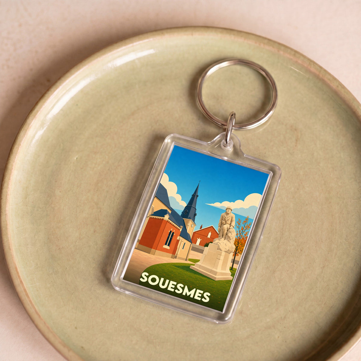 Porte-clés souvenir de la ville de Souesmes avec une illustration stylisée de son patrimoine.