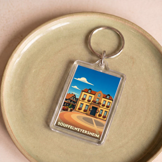 Porte-clés souvenir de la ville de Souffelweyersheim avec une illustration stylisée d'un bâtiment typique.