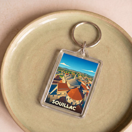 Porte-clés souvenir de la ville de Souillac avec une illustration stylisée de ses dômes.