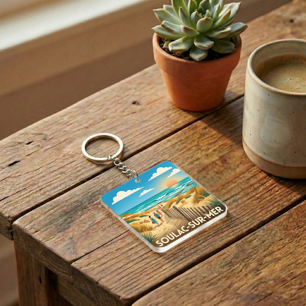 Porte-clés souvenir de la ville de Soulac-sur-Mer avec une illustration de plage stylisée.
