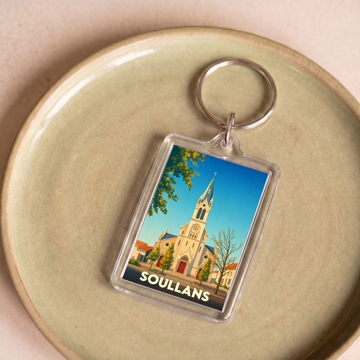 Porte-clés souvenir de la ville de Soullans avec une illustration stylisée de son église.
